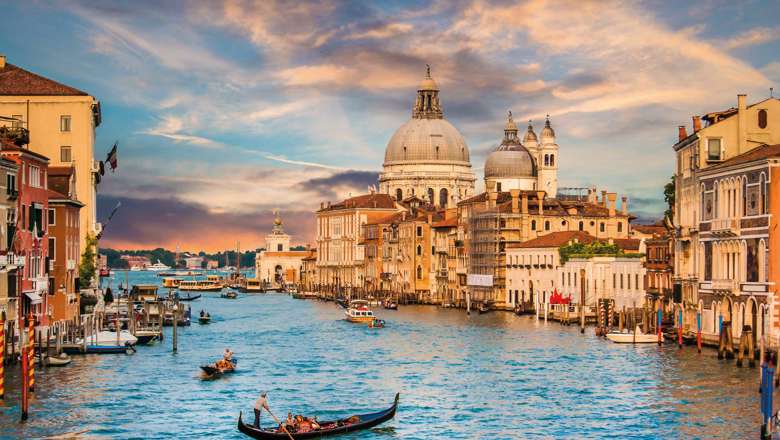 Traditional Gondola On Famous Canal Grande With Basilica Di Santa Maria Della Salute In Golden Evening Light At Sunset In Venice Italy 