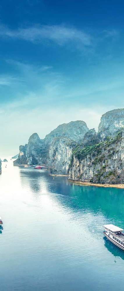 Tourist Junks Floating Among Limestone Rocks At Ha Long Bay, Vietnam