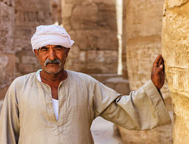 Man leaning on Karnak Temple, Egypt