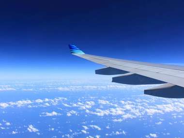 View of aeroplane wing in the sky over clouds