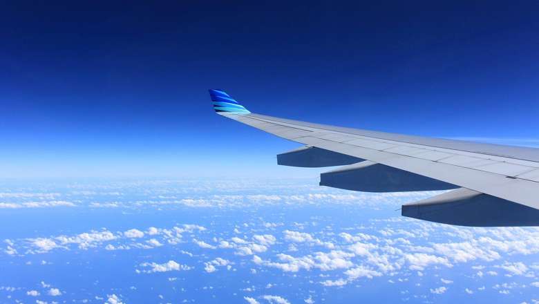 View of aeroplane wing in the sky over clouds