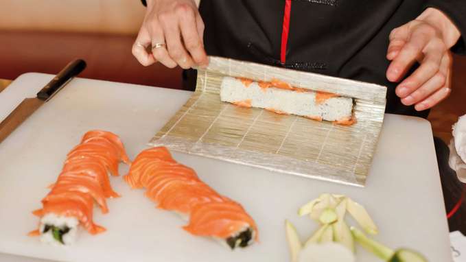 Woman rolling sushi with bamboo rolling mat, Japan