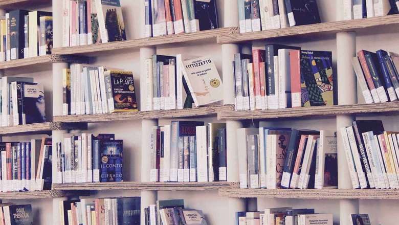 Books lined up on a wooden bookshelf