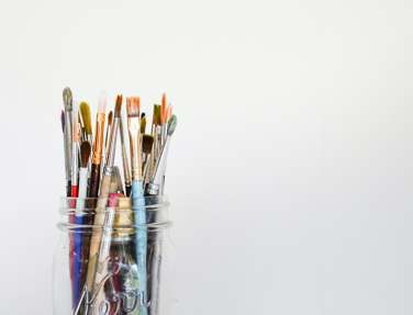 Paint brushes sitting in a glass