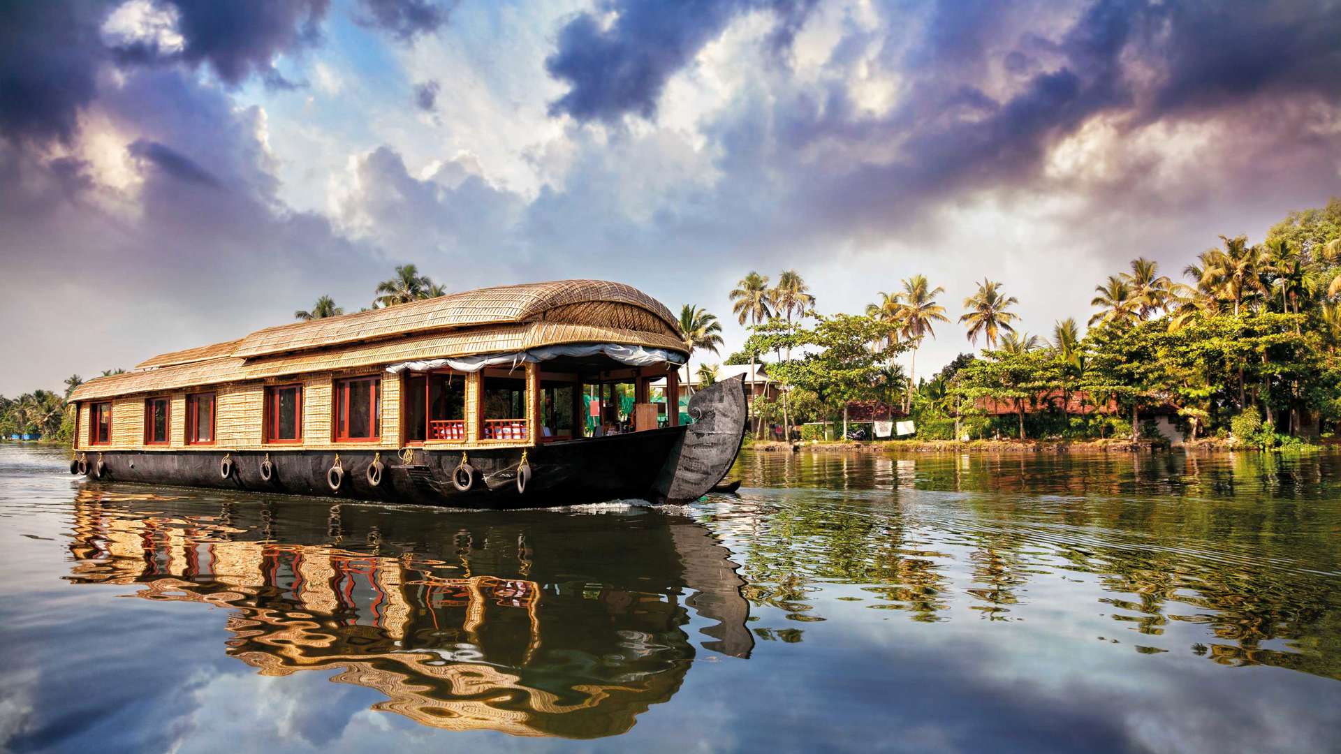 House Boat In Backwaters Near Palms At Cloudy Blue Sky In Alappuzha Kerala, India